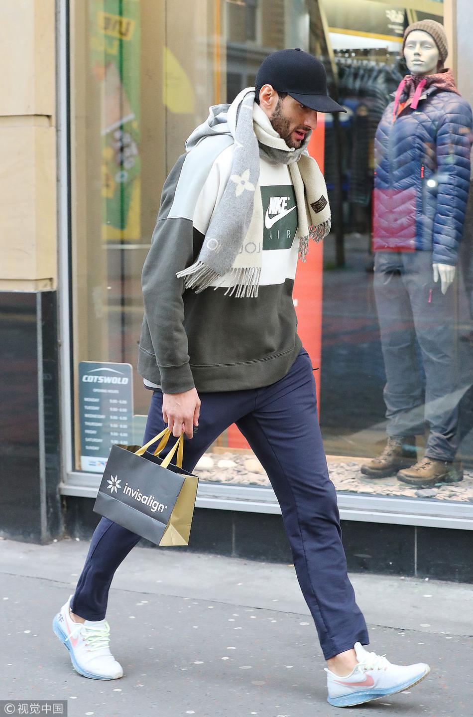 走出商店的费莱尼，一手提着刚买的物品，一手拿着手机查看。他那蓬松的爆炸头即使在远处也异常醒目。这一瞬间，他不再是球场上那个威风凛凛的巨人，只是一个在英伦冬日里处理着琐碎日常的普通人，脚步匆匆地融入人海。