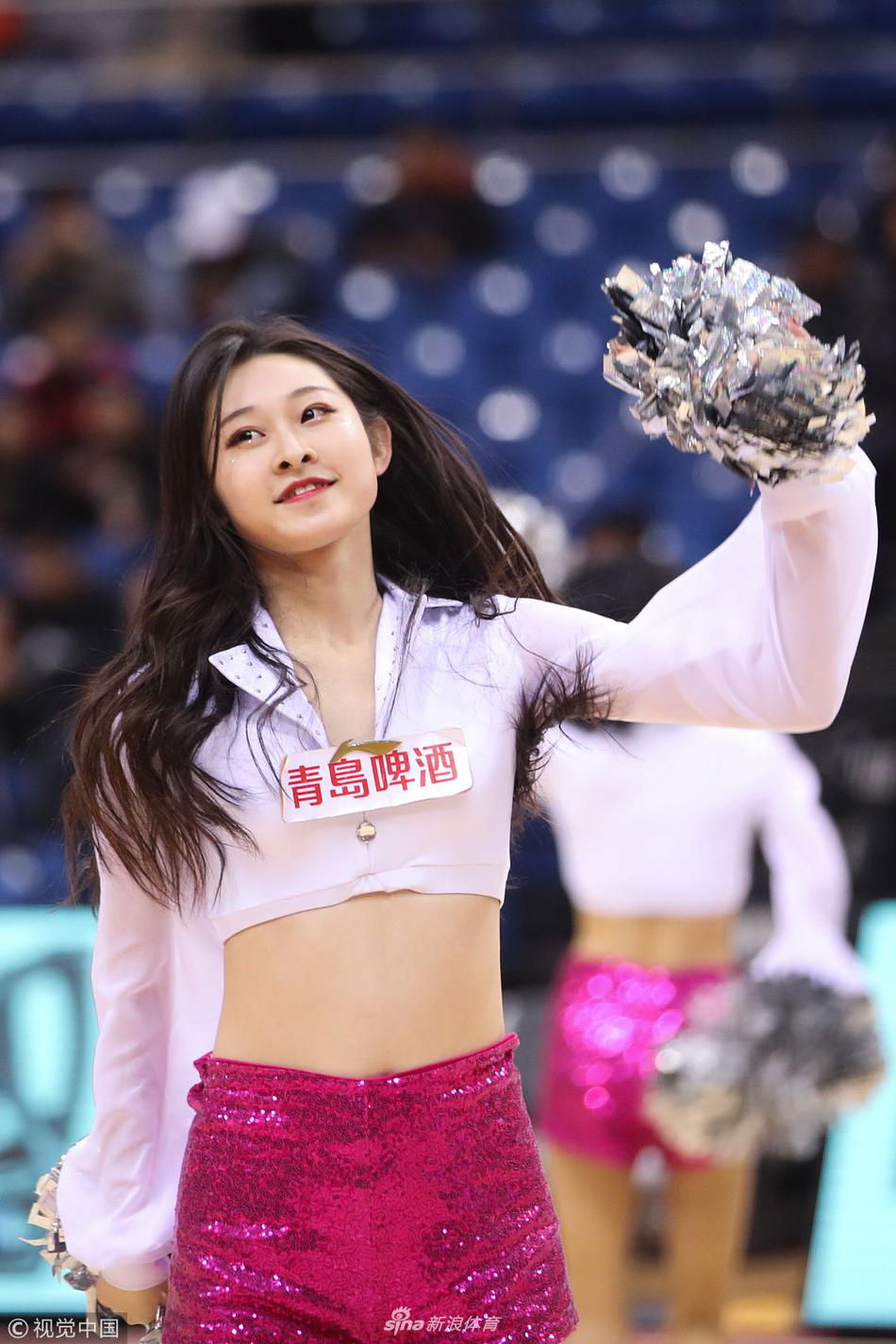 在灯光璀璨的球场上，一位篮球宝贝正进行着高难度的舞蹈动作，她身姿挺拔，表情专注，展现出职业啦啦队员的专业素养与无限活力，为铁血的篮球赛场增添了一抹亮色。