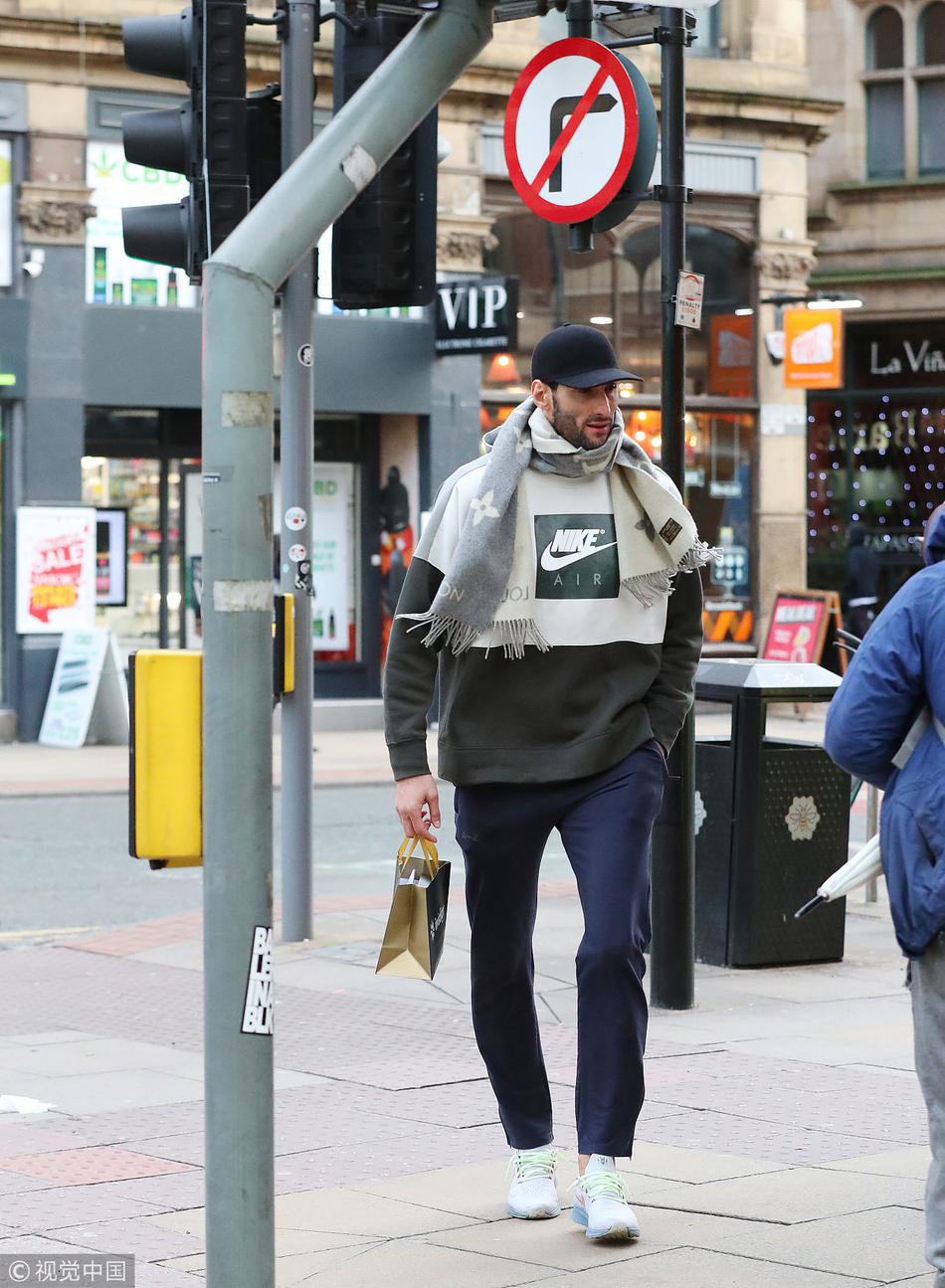 镜头拉近，费莱尼摘下脸上的墨镜，露出了一张毫无表情的脸。标志性的蓬蓬头在寒风中显得有些凌乱，仿佛也诉说着他内心的不平静。他眉头微蹙，眼神中透出一丝疲惫与迷茫，似乎正在思索着自己在老特拉福德不确定的未来。