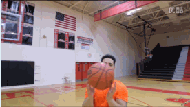 球员低伏身体进行原地低姿运球练习，眼睛目视前方，球感专注