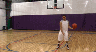 球员单手运球推进，运球手从球的侧面划过，带动球向内侧移动，同时左脚向同侧做试探步，头部虚晃，随后手迅速将球向外侧推出，完成变向，整个过程行云流水。