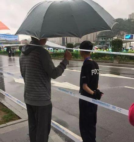 暖心市民为警察小哥撑伞遮雨