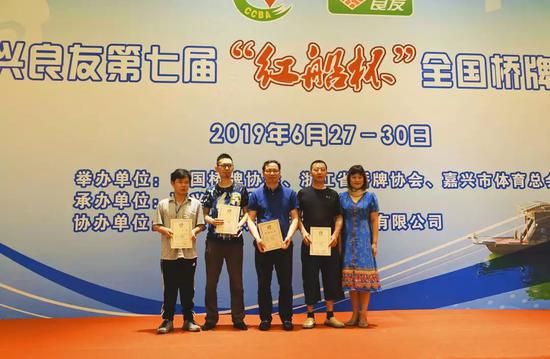 浙江省桥牌协会秘书长章瑜(右)为第四名浙江新翔队颁奖
