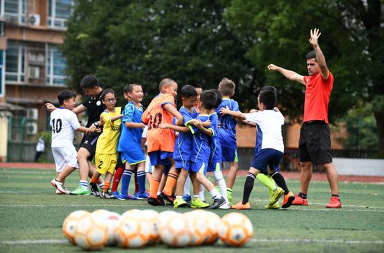 这是马丁内斯（右一）指导孩子们练习足球。新华社记者杨文斌摄