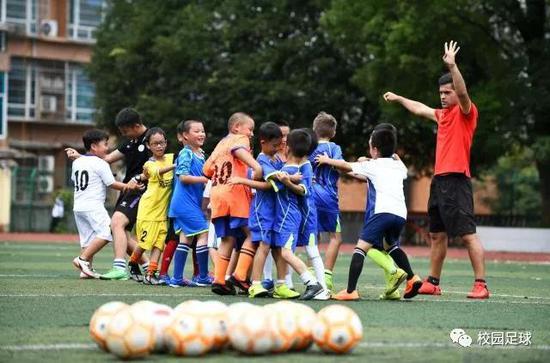  来自智利的足球教练马丁内斯（右一）在贵州凯里指导孩子们练习足球。新华社记者杨文斌摄