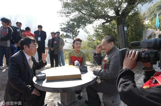 2003年10月8日,金庸登顶陕西华山参加“华山论剑”活动,金庸在过聂卫平的残局关 图 / 视觉中国