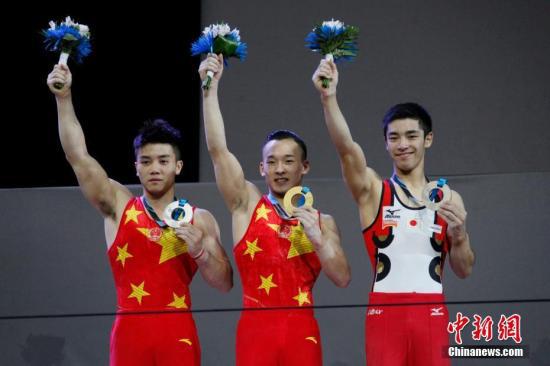 资料图：肖若腾（中）在2017年体操世锦赛获全能金牌。 中新社记者 余瑞冬 摄