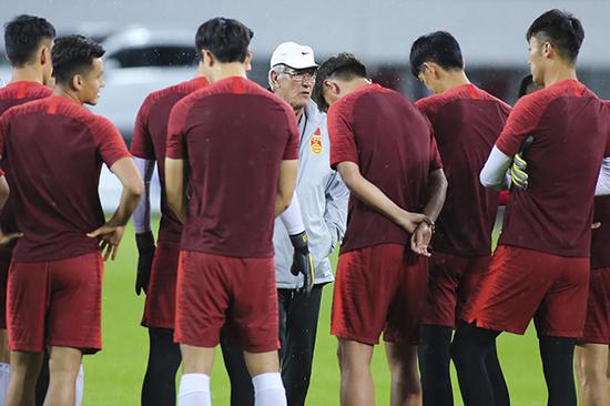 中国男足在雨中训练备战。视觉中国