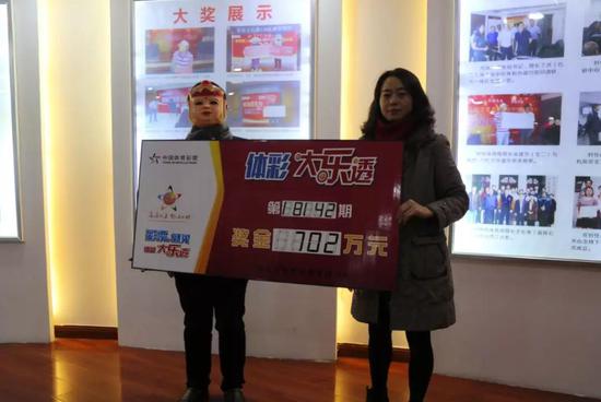重庆市体彩中心副主任熊鹰为702万大奖得主颁奖