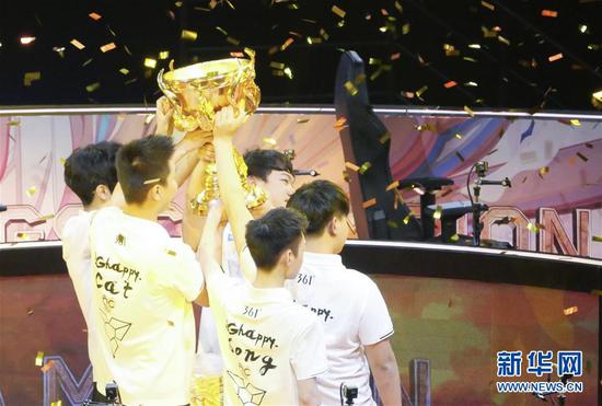 QGhappy战队队员向观众展示冠军奖杯。 新华社记者孟鼎博 摄