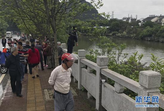 ↑图为4月22日，市民在翻舟事发地围观。 新华社记者周华摄