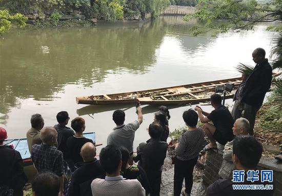 ↑图为4月22日，市民在翻舟事发地围观。 新华社记者周华摄