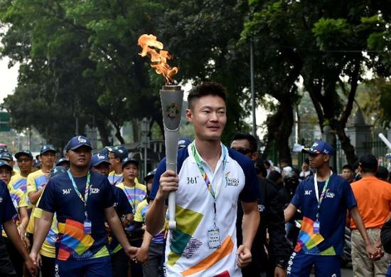 来自中国的火炬手张培萌在传递火炬。新华社记者岳月伟摄