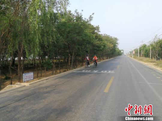 民众在衡水湖马拉松赛道上骑行。 王鹏 摄
