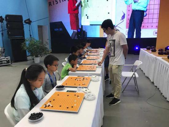 中国棋院杭州分院的职业棋手正在与小棋手下指导棋