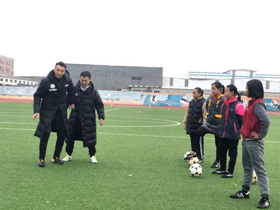 理事长刘成和理事樊海东为强蛟镇中心幼学的女足队员上足球公好课