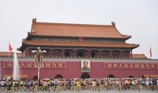 参赛选手在2016北京马拉松赛中经过天安门广场↑新华社记者孔卉摄
