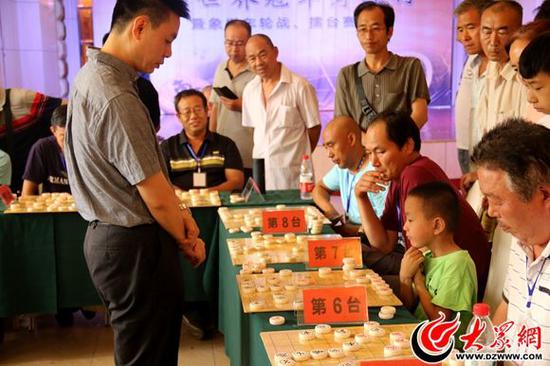 国际特级象棋大师许银川与8岁小棋手乔自谦对弈中