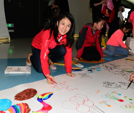 图说：中国冬奥会首金获得者杨扬和孩子们一起画画。