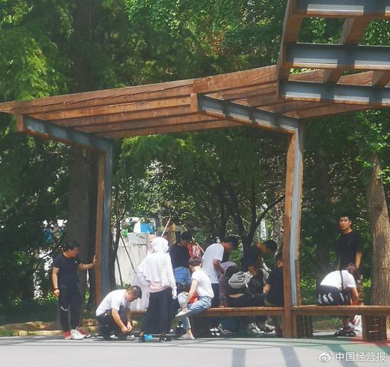 6月15日中午，北京工人体育场小公园内，准备参加抽签活动的人正在换鞋。