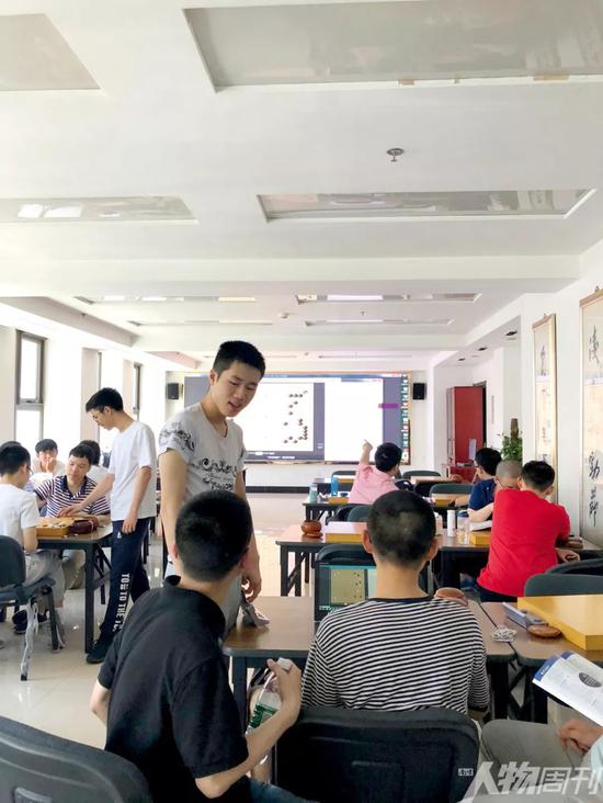 中国围棋国家队训练室，棋手用绝艺AI复盘交流学习