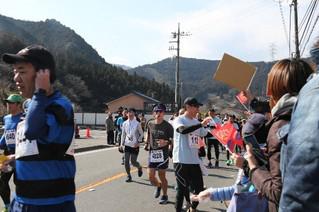 17日,30公里赛事的首都媒体跑团参赛者和助威队伍招手