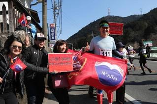 17日,人民网参赛跑者郑紫豪手持贵州茅台横幅,与助威团队在30公里赛程合影