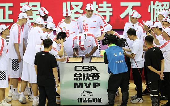 辽宁本钢队球员哈德森（中）在获得总决赛MVP（最有价值球员）后为自己的手印签名。