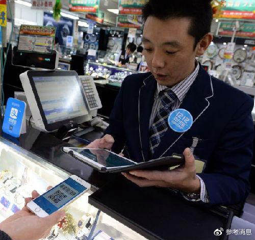 资料图片：在日本首都东京，一家商场的店员使用支付宝为顾客结账。