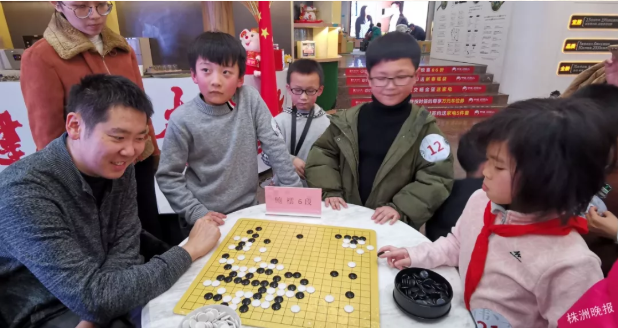 鲍橒在活动现场指导孩子下棋(记者肖蓉 摄)
