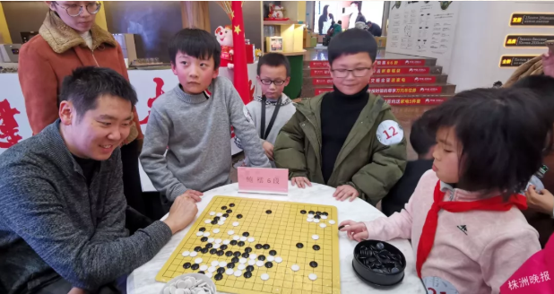 鲍橒在活动现场指导孩子下棋（记者肖蓉 摄）