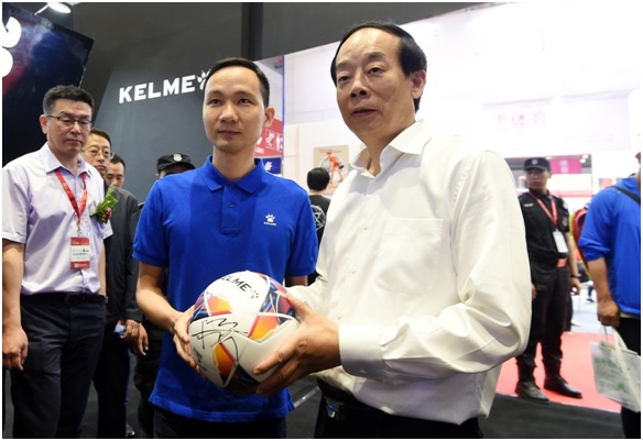 卡尔美（中国）有限公司总经理柯永祥（左）为国家体育总局副局长赵勇（右）赠送签名足球