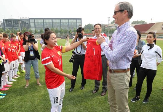 图二：中方运动员代表向耐克集团公共事务高级副总裁O’ Hollaren Sean赠送签名球衣