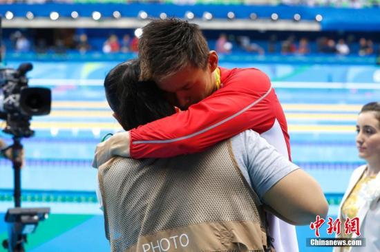 图为赛后一位摄影记者拥抱安慰孙杨。中新网记者 富田 摄