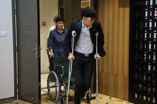 柯洁从轮椅拄起拐杖站起来