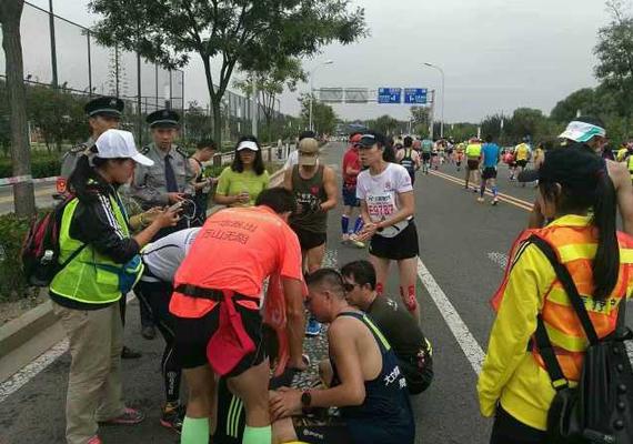 北京天坛医院神经内科大夫申园（白）在北马比赛过程中看照顾伤者