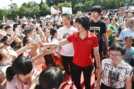 9月17日，中国女排主教练郎平与学生互动。新华社 图