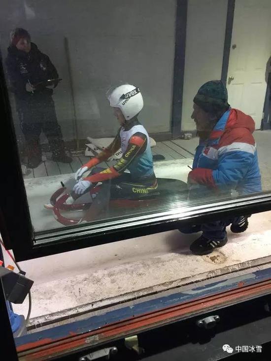 比赛时，中国雪橇队主教练Wolfgang Heinrich Schädler陪同胡慧兰等待出发