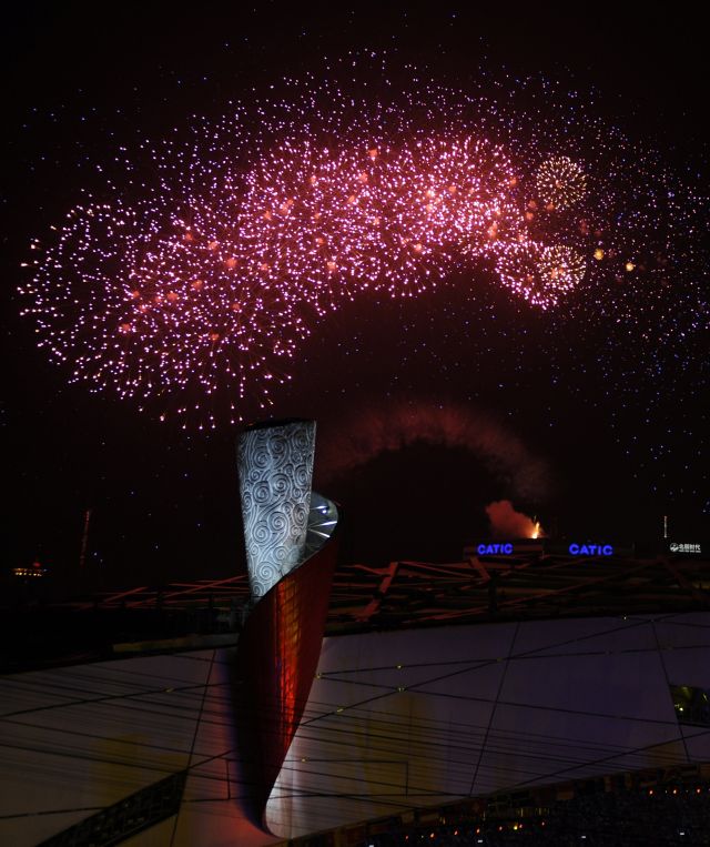 图为2008年8月24日，第29届夏季奥运会闭幕式在国家体育场——“鸟巢”举行。图为燃放的焰火在主火炬塔上空绽放。新华社记者张铎摄