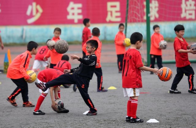 孩子们在南宁市西乡塘社区北湖街道秀湖社区的青少年足球训练场接受训练,新华社记者周华摄