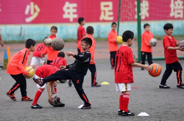 孩子们在南宁市西乡塘社区北湖街道秀湖社区的青少年足球训练场接受训练，新华社记者周华摄