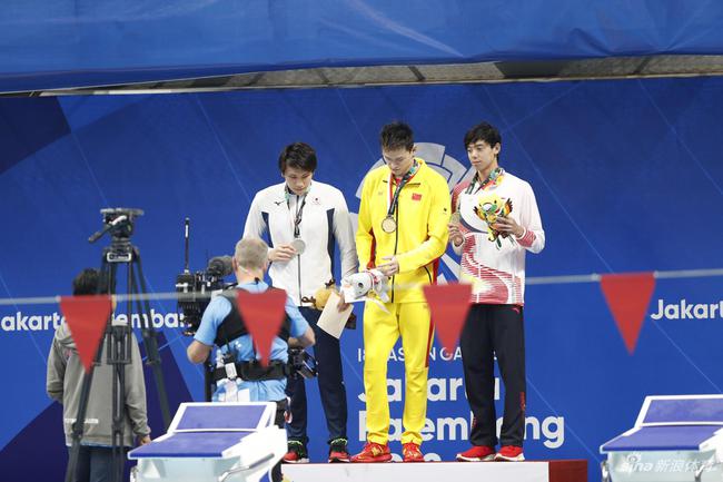 领奖台上的两位中国运动员穿着不同品牌的服装