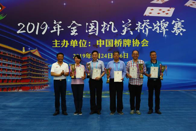 中国桥牌协会副秘书长李国华(左)为四至八名颁奖