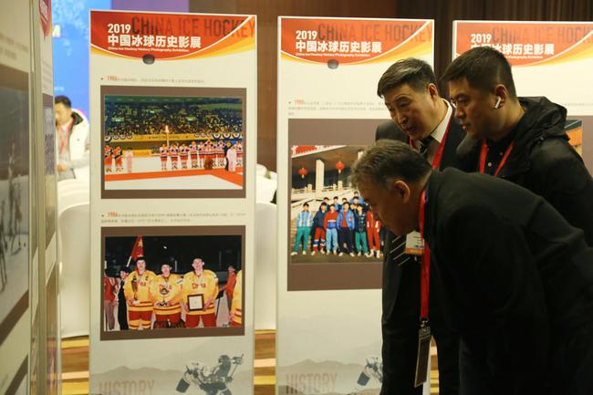 现场嘉宾欣赏中国冰球历史影像展上的老照片
