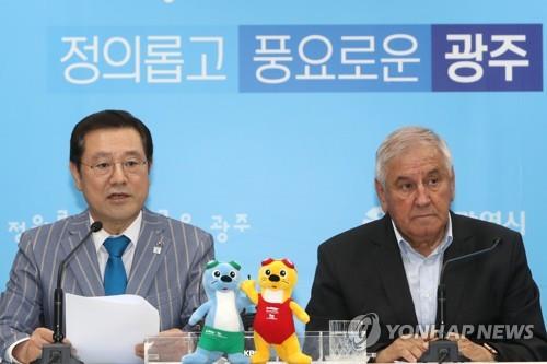 5月23日,国际泳联(FINA)执行主任马库莱斯库(右)与光州市长李庸燮联合召开记者会。(韩联社)