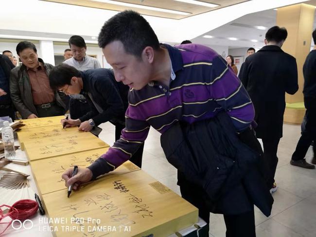 赛前在棋盘上签名的古力九段,本轮挑落“快枪”手李钦诚