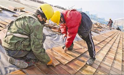 日前，在延庆冬奥村，工作人员在索道A1下站进行屋面木瓦铺设。 　　任 超摄（新华社发）