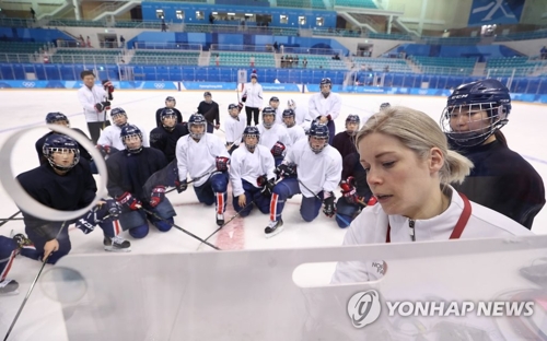 2月7日下午，在江原道江陵市关东冰球中心，韩朝女子冰球联队主教练萨拉·穆雷（右一）向参加训练的韩朝联队队员们说明战术。（韩联社）