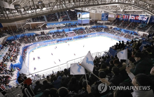 资料图片:2月14日下午,在江原道江陵市关东冰球中心,韩朝联队在平昌冬奥会女子冰球小组赛第三轮中对战日本队,看台上座无虚席,观众为运动员加油鼓劲。(韩联社)
