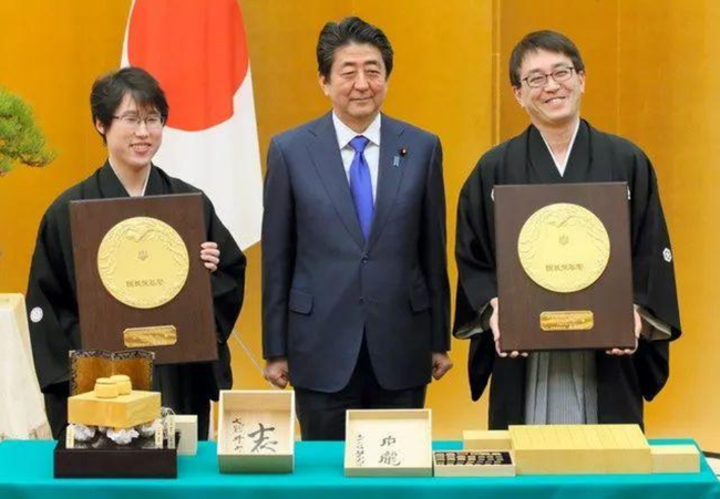 日本首相安倍晋三向两位棋手赠与奖状以及纪念品